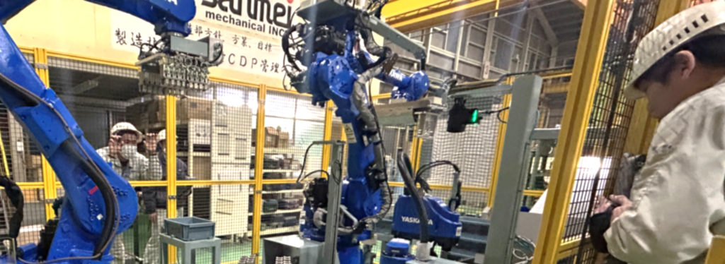 出荷前の自動化ロボットセルを試運転調整するエンジニアによる立上げ作業