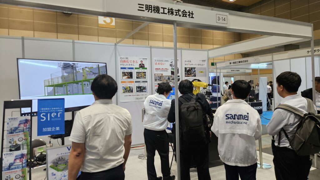 関西ロボットワールド2026の三明機工ブースで工具交換自動化デモを紹介する様子