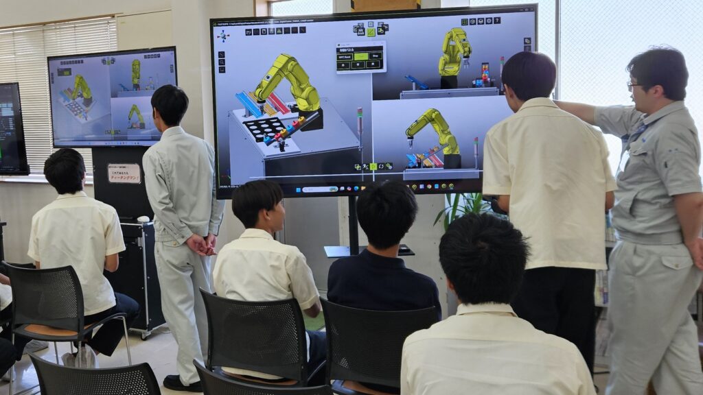 デジタルトレーナーによるロボットシミュレーションを見学するロボットアイデア甲子園参加者